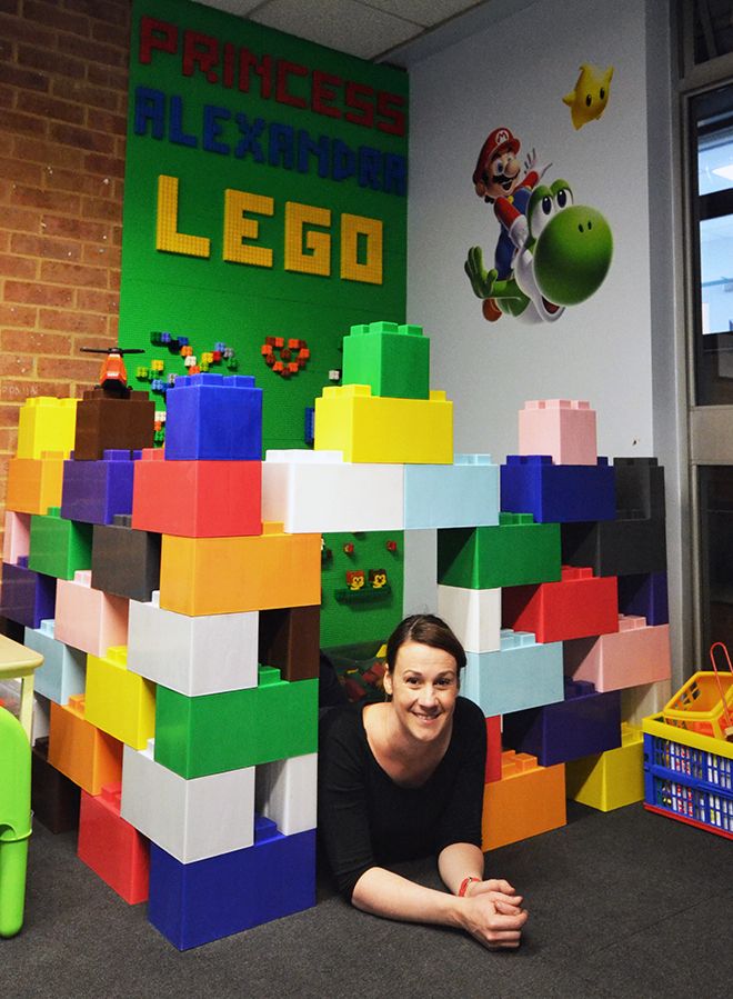 Lili Giacobino lies underneath the archway of her Lego design in the Kingston Hospital waiting room