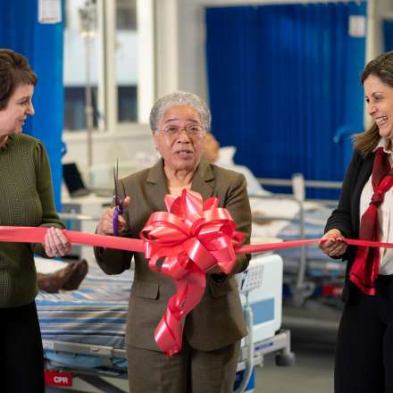 Dame Elizabeth Anionwu (centre) cuts a ribbon to open the new pharmacy skills simulation suites at Kingston University. Simulation Unit Manager Jo Low (left) and Head of the Pharmacy Department, Professor Reem Kayyali (right) were heavily involved in the creation of the facilities