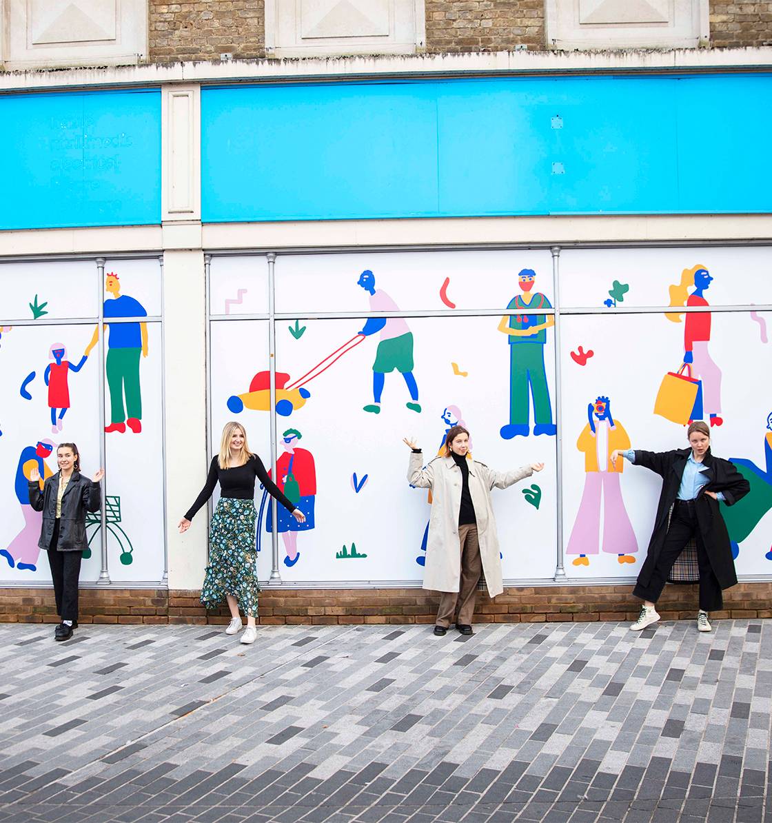 Students in Kingston town centre standing outside colourful drawn mural showing illustrations of people 