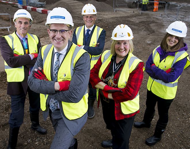 Picture of three men and two ladies in safety wear on the Town House building site.