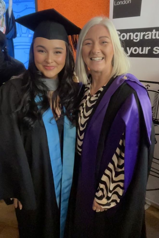 Two people smiling at a graduation ceremony