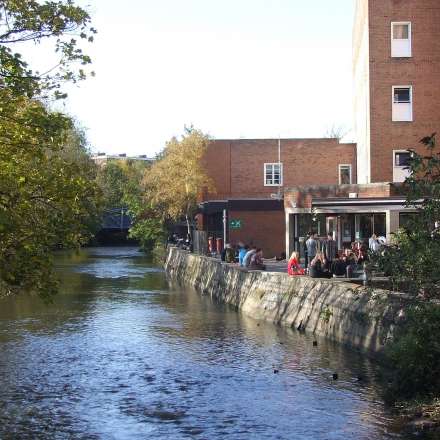 Students gathering outside the Students' Union bar by the Hogsmill River
