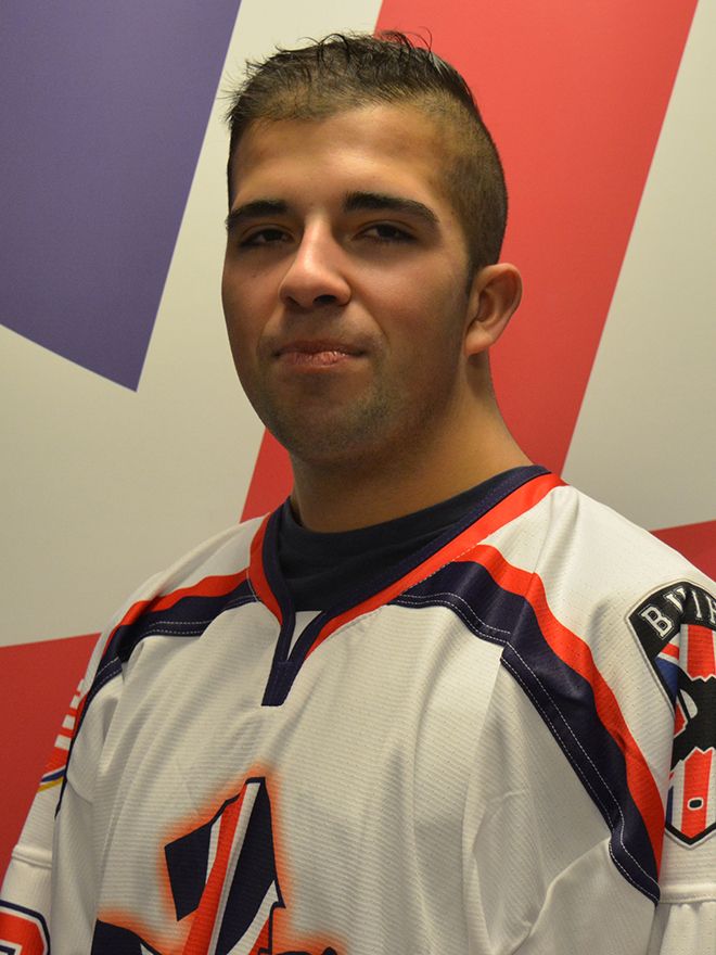 Sam Cheema stands in front of Union Jack flag in his white Great Britain ice hockey jersey