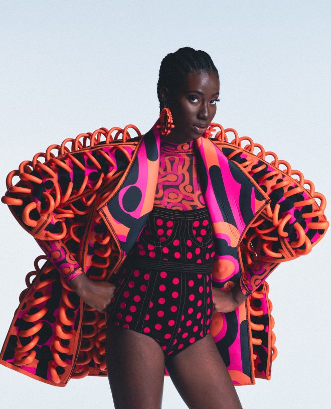 Black model wearing a vibrant pink and orange outfit