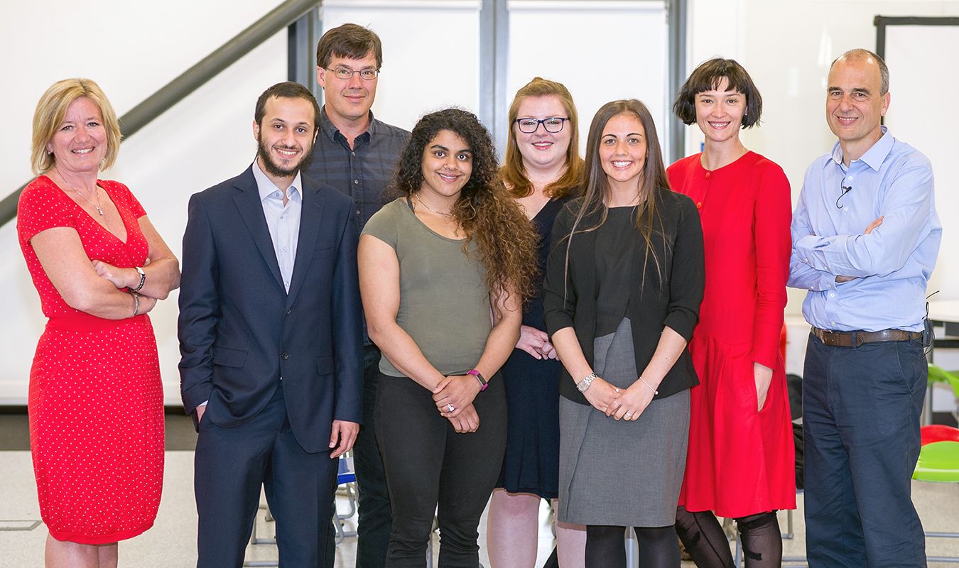 Eight people line up for a group photograph. The six contestants are joined by Etienne Duval and Professor Andrea Petroczi