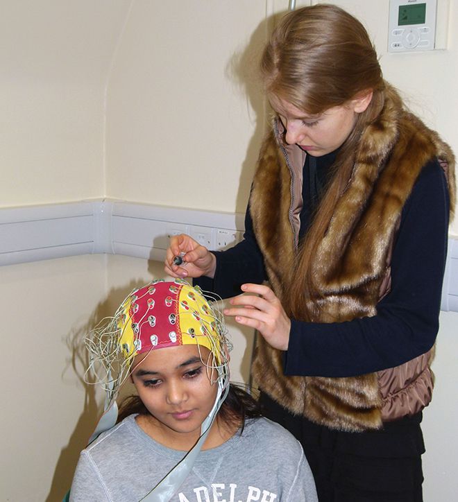 Kingston University PhD student Angela Medvedeva experiments with the electroencephalogram (EEG) on fellow PhD student Jawaria Farooq