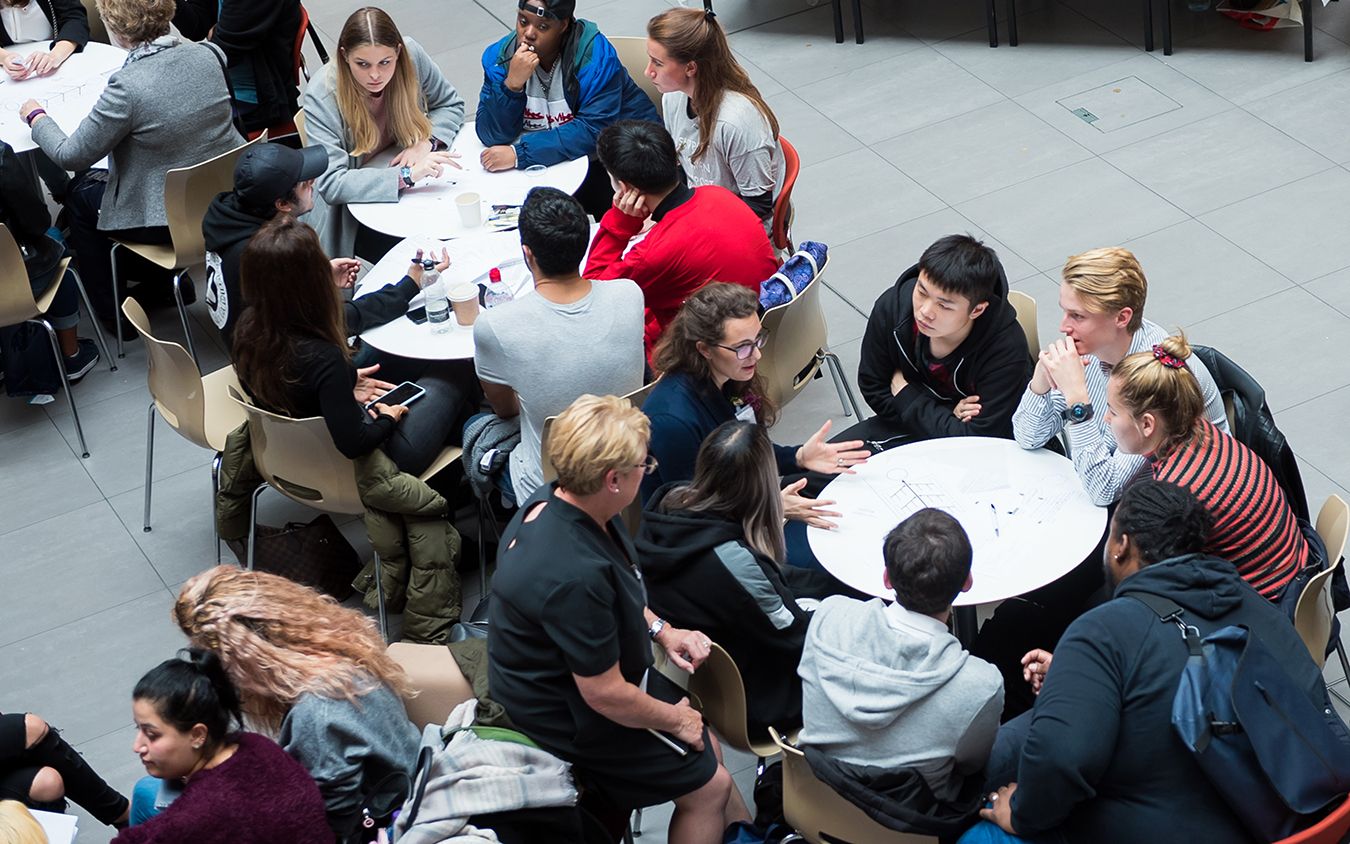 A photograph from above of a group of students at the hackathon