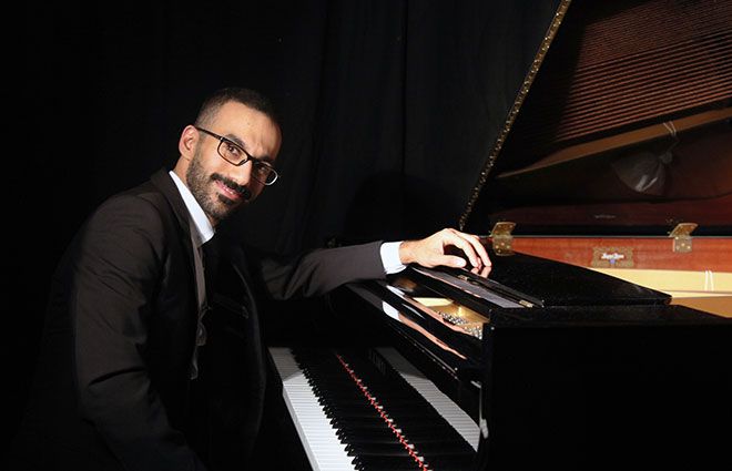 Abdullah Khalaf sitting by a grand piano
