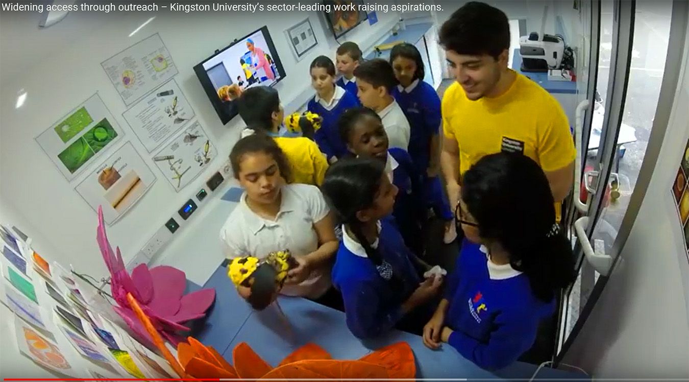 A photo of a student ambassador with a number of children from Reach academy Feltham