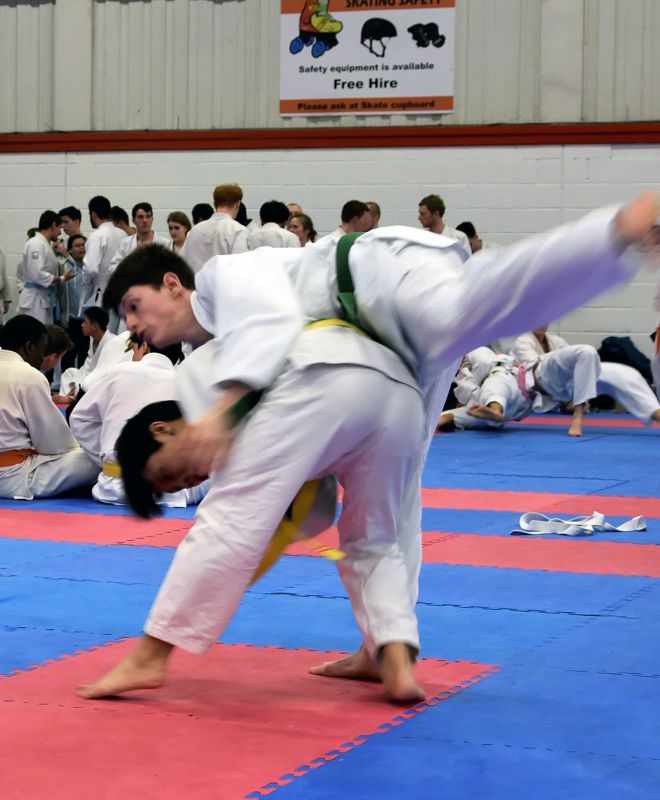 two jiu jitsu fighters fight with one on top of the other on the mat