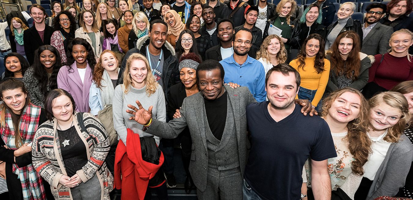 Picture of comedian Stephen K Amos surrounded by students at the 2015 media Summit.