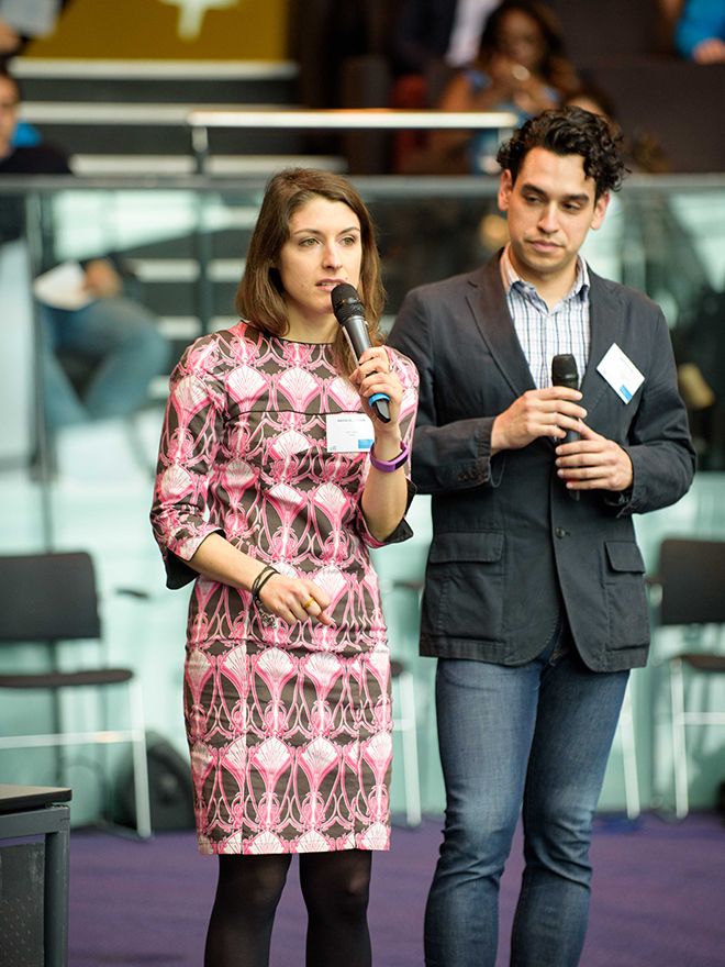 Two contestants stand with microphones as they address the judges