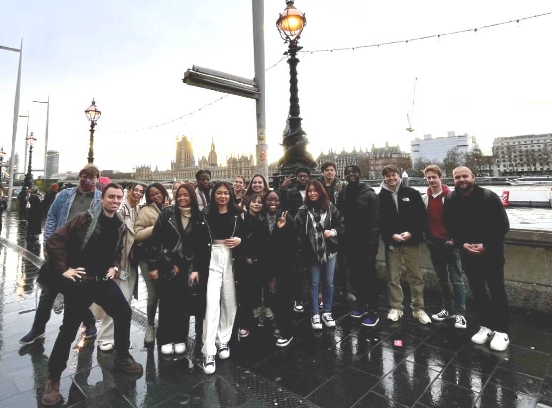 Groups of students on trip to London Dungeon, standing by the River Thames