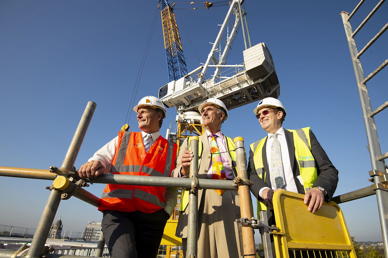 A photo of Steven Spier, David Edmonds and Roger Forsdyke at the top of a building in hard hats. 