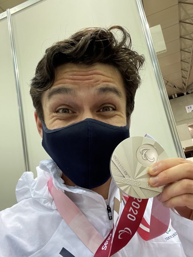 Oliver Lam-Watson holding his silver medal at the Paralympic Games