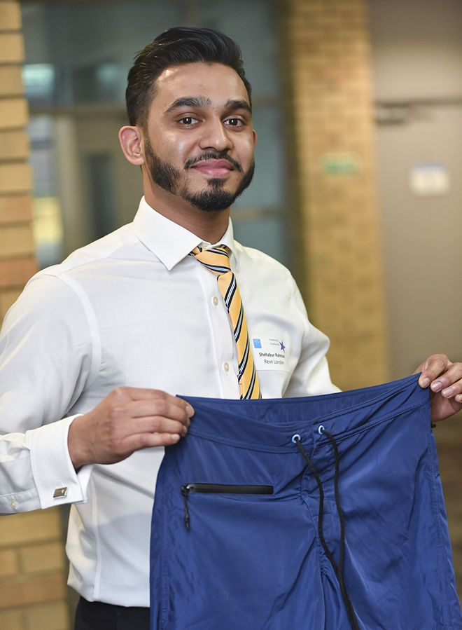 Kingston University student Shehabour Rahman holds a pair of swimming shorts with water resistant pockets