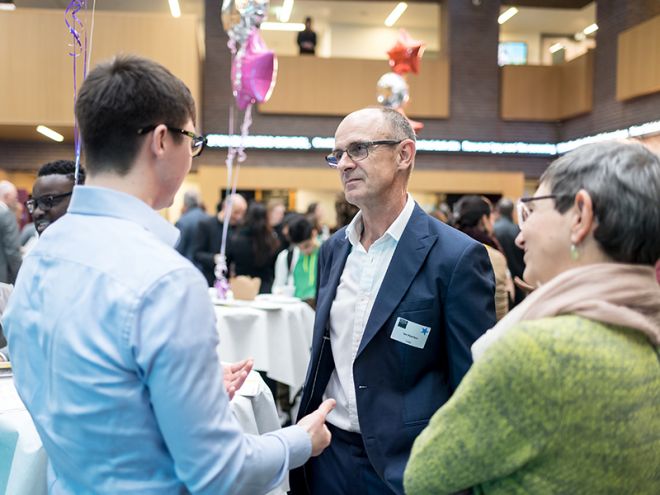 student speaks to member of the Bright Ideas judging panel and Dr Martha Mador at the networking event