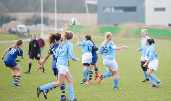 female athletes playing a game of football