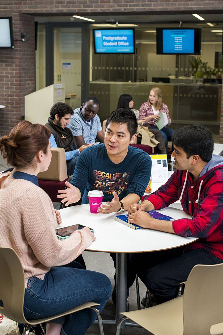 Postgraduate students in discussion in the Business School building