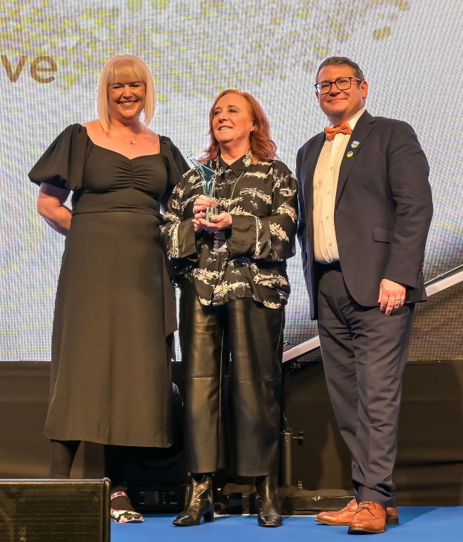 Three people at an awards ceremony