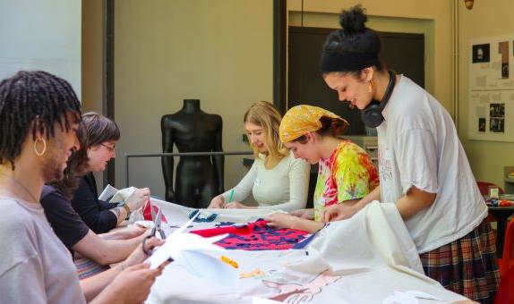 five KU students decorating a banner together