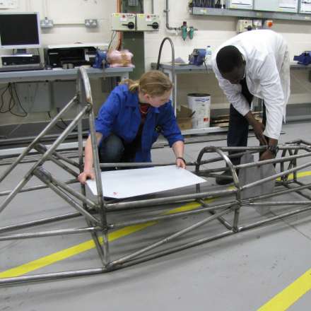 Reviewing a motorcar frame in the automotive engineering lab