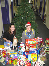 Kingston University Studentsâ€™ Union representative Becky Pearson, left, and Mark Callaby, right, get in the festive spirit surrounded by presents being donated to youngsters at CHASE hospice. 