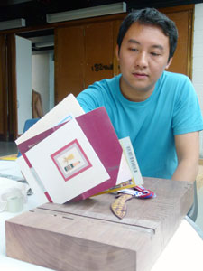 Yanchee with the prototype he produced to test his shelf design.